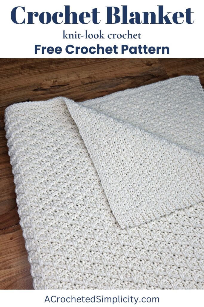 A cream colored knit-look crochet blanket pattern folded into a square with one corner pulled back.