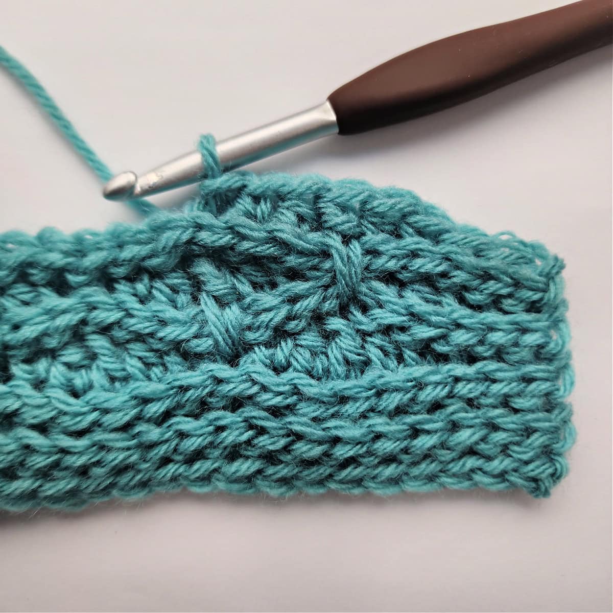 The beginning of a knit-look stitch pattern repeat being worked in row 9.