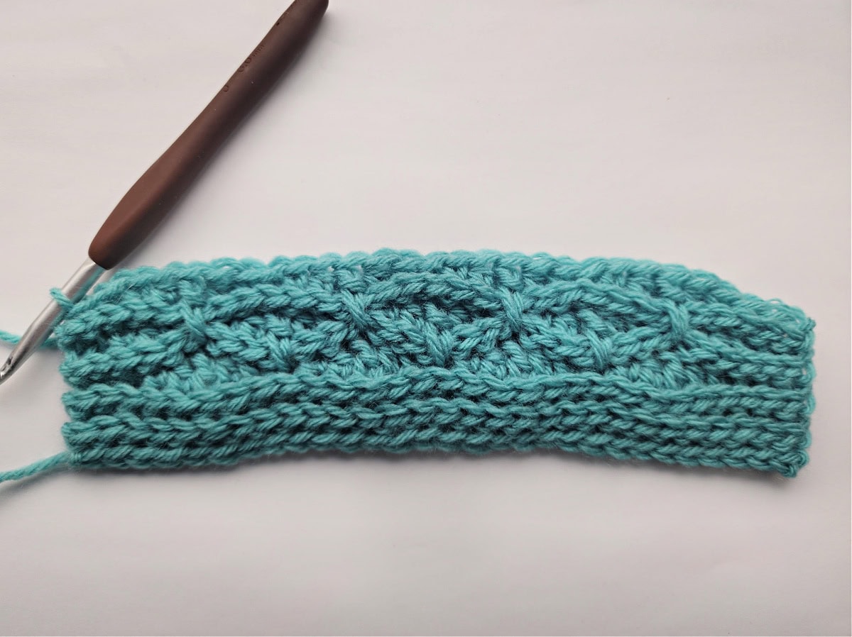 Nine rows of a knit-look crochet blanket swatch complete.