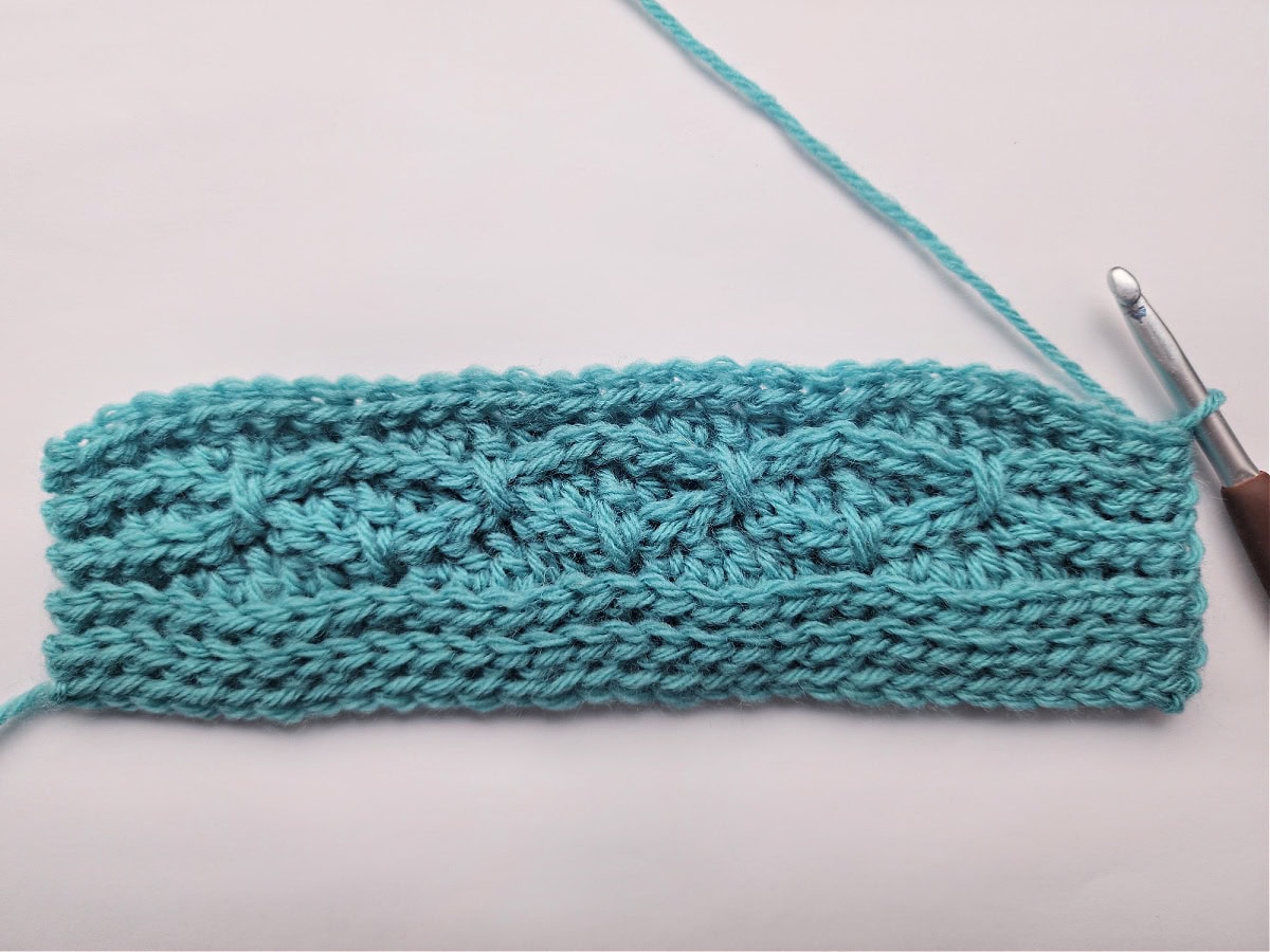 Right side of a swatch of ten rows of a knit-look crochet blanket.