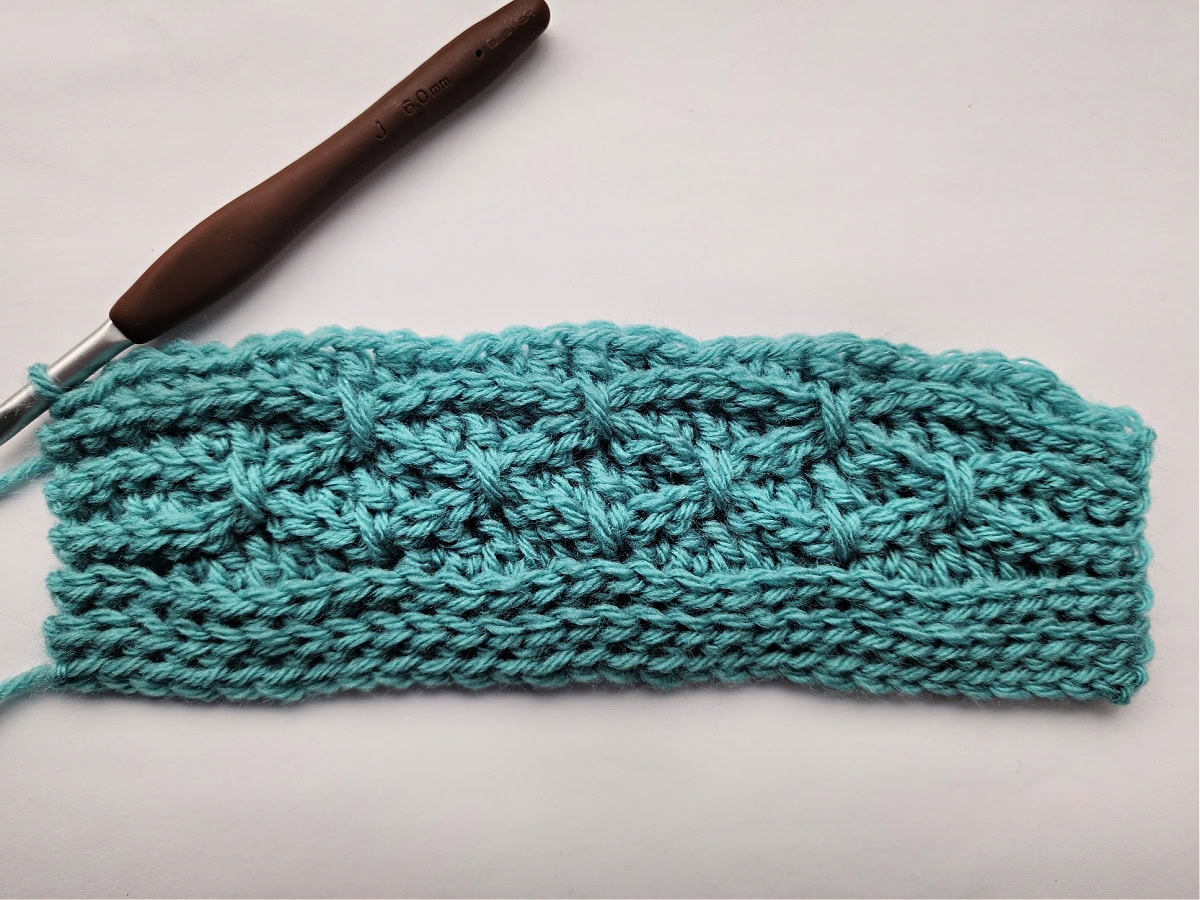 Eleven rows of a knit-look crochet blanket swatch complete.