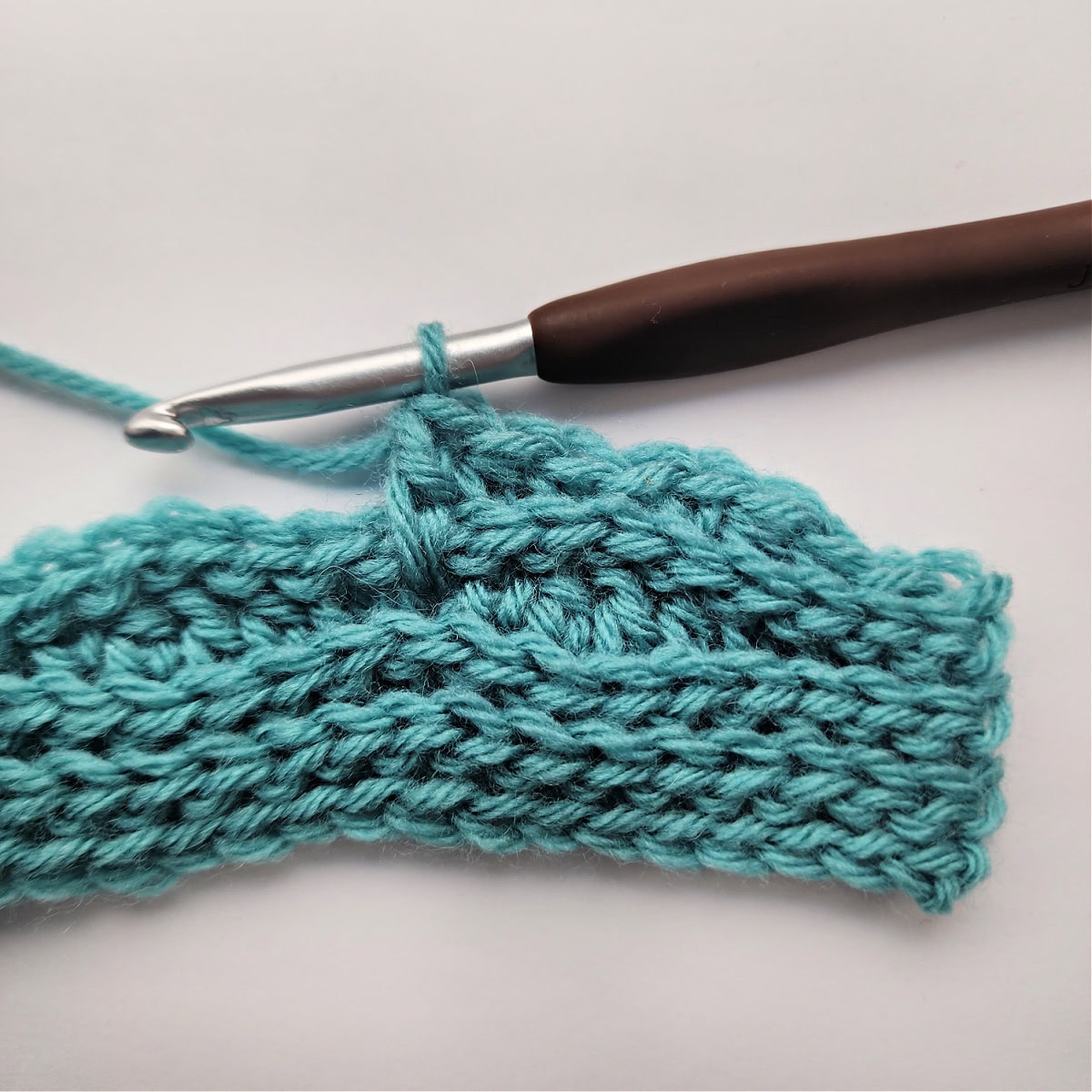 A double crochet stitch worked two rows down.