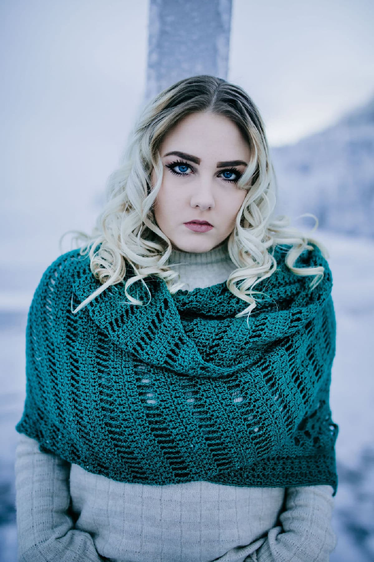 Woman with a green crochet shawl draped around her shoulders.