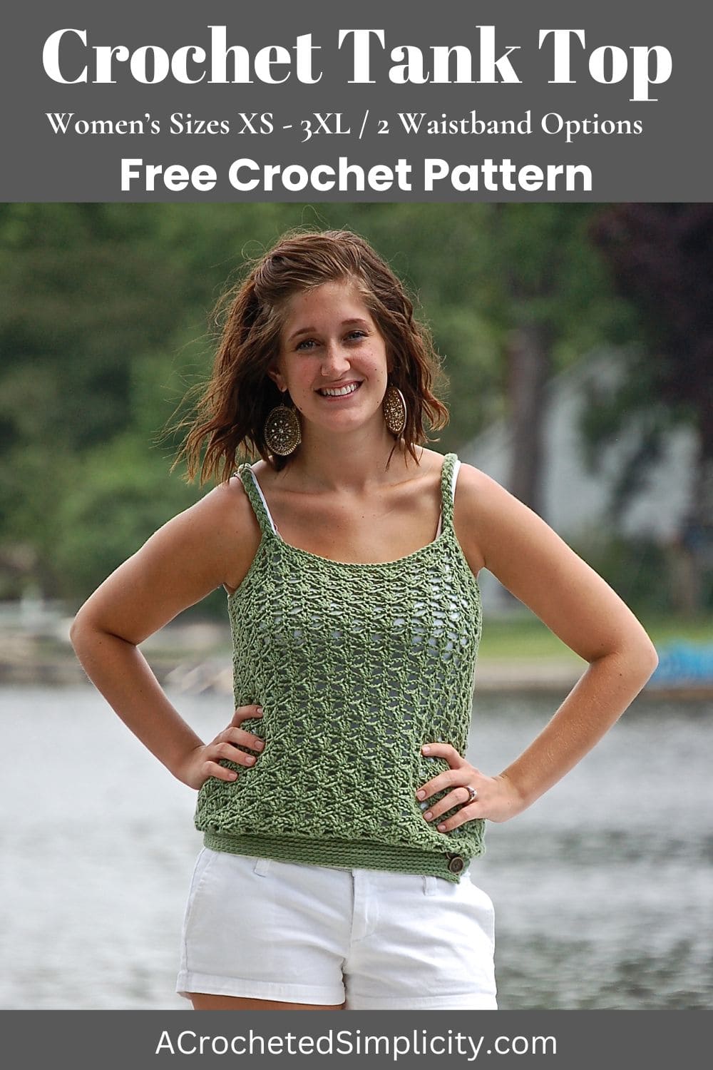 Woman wearing a green crochet tank top with her hands on her waist standing in front of a lake.