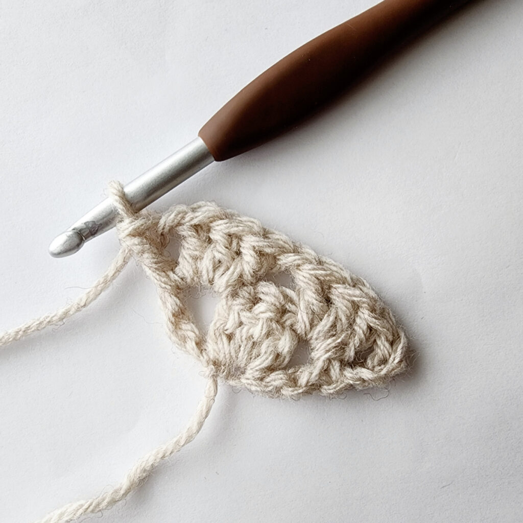 Second row of increase of a crochet granny square motif.