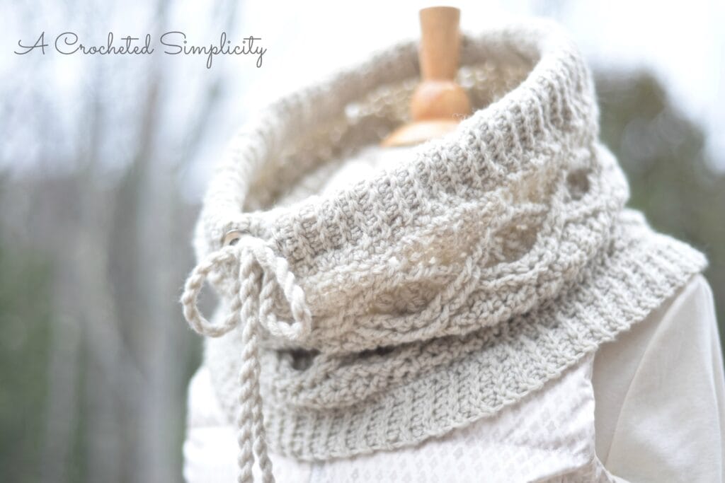 Crochet cowl with cables and a drawstring.