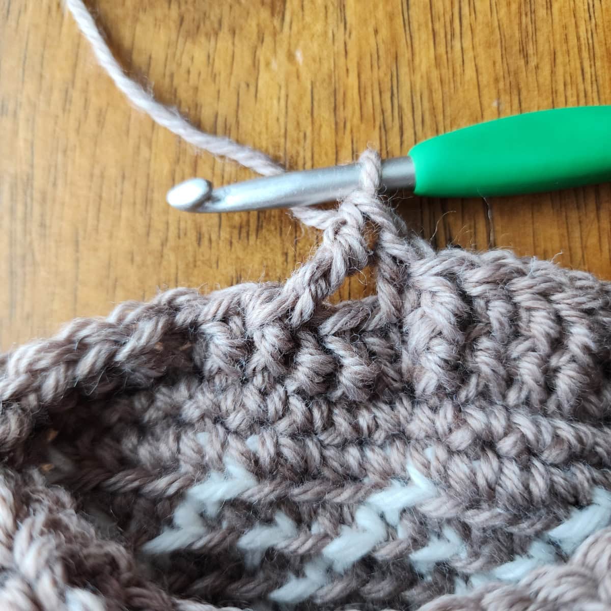 Working the 4-strand cable twists of the decorative cuff of the crochet slipper boot.
