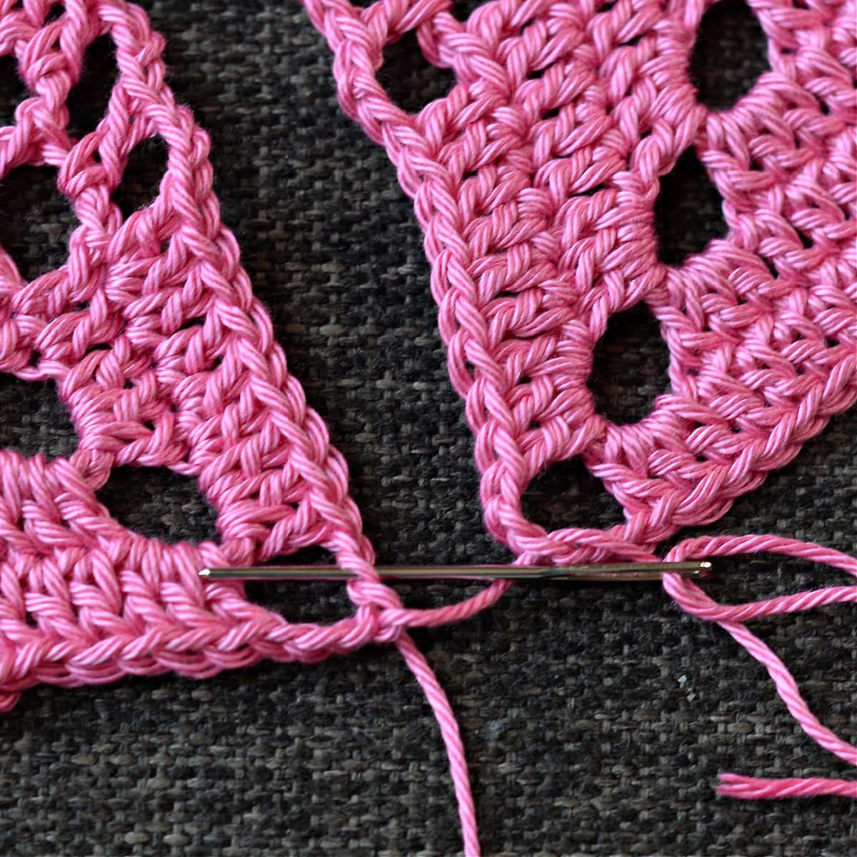 Using a needle to seam the granny squares together.