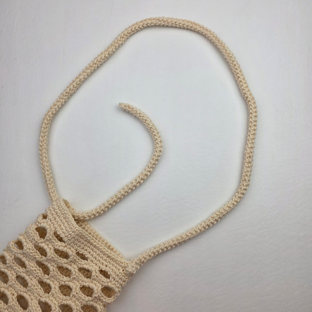 Adding an adjustable strap to a crochet water bottle holder.