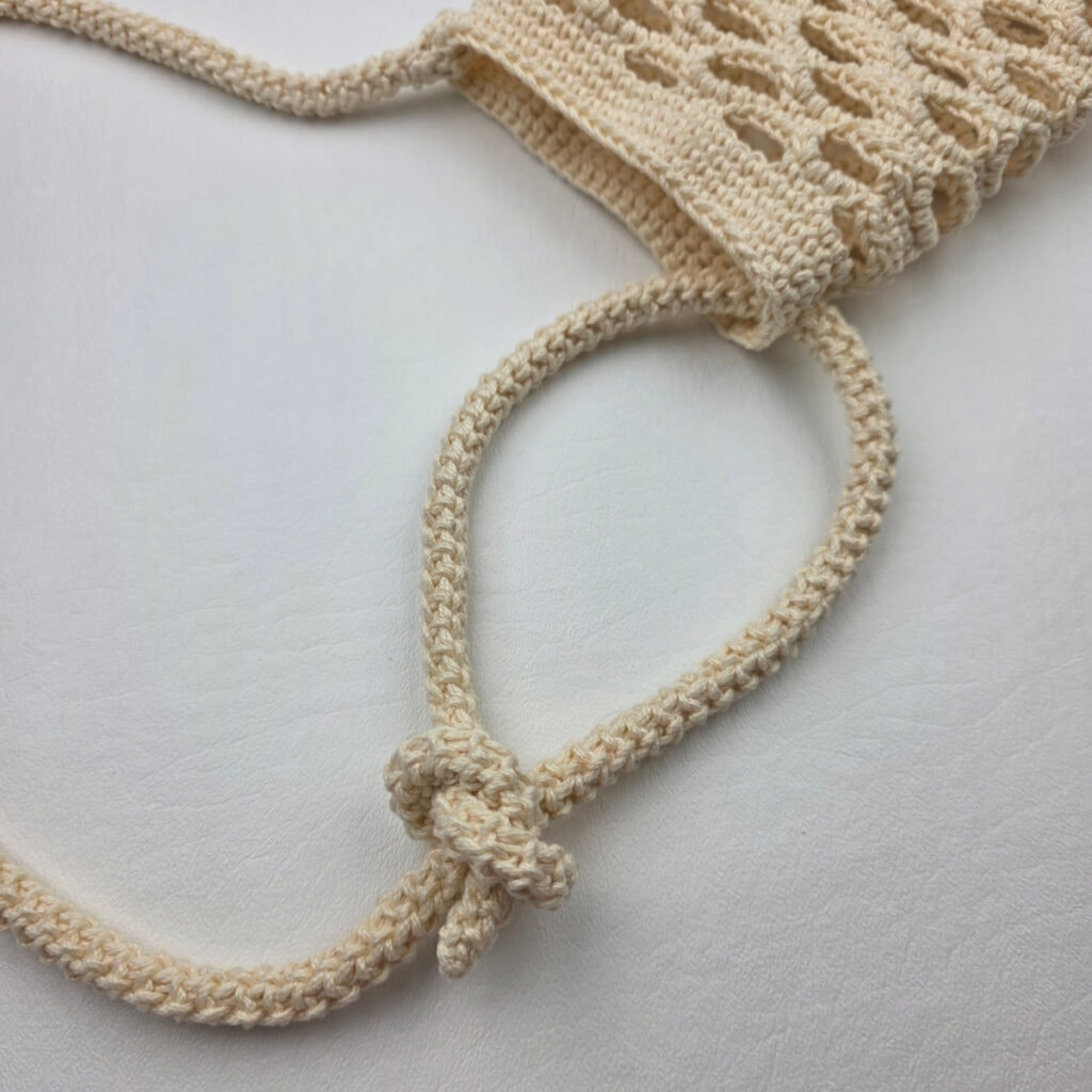Adding an adjustable strap to a crochet water bottle holder.