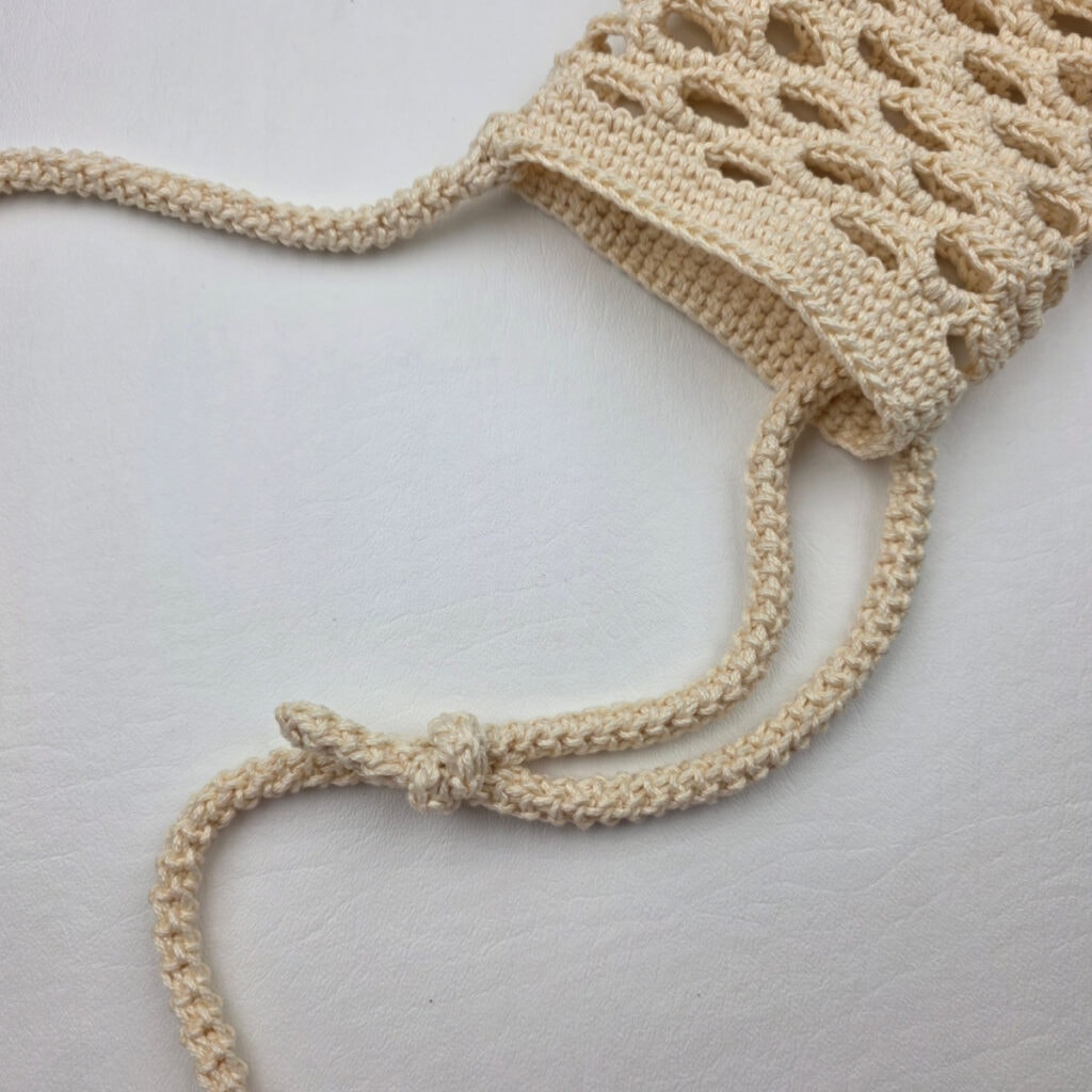 Adding an adjustable strap to a crochet water bottle holder.