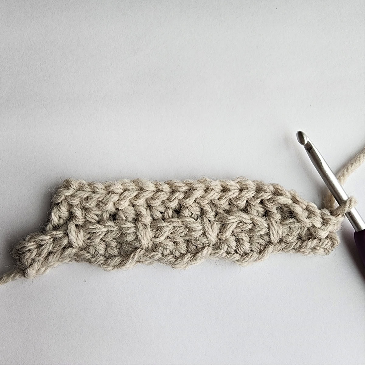 Starting row 5 of the crochet ornament with a purple crochet hook.