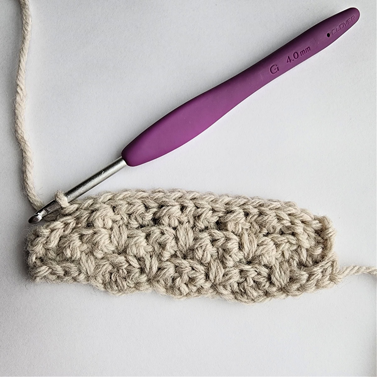 Row 6 of the crochet ornament with a purple crochet hook.