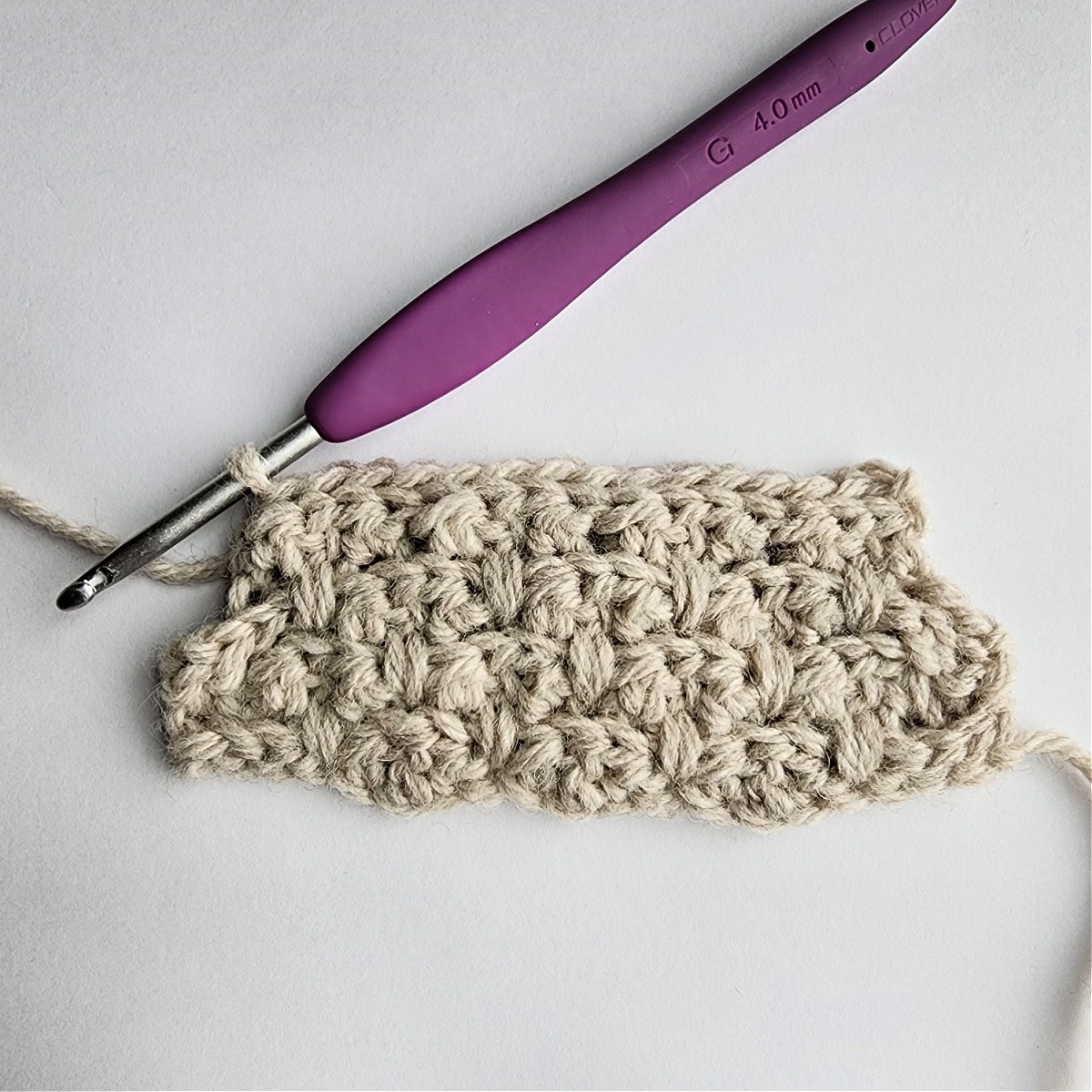 Row 8 of the crochet ornament with a purple crochet hook.