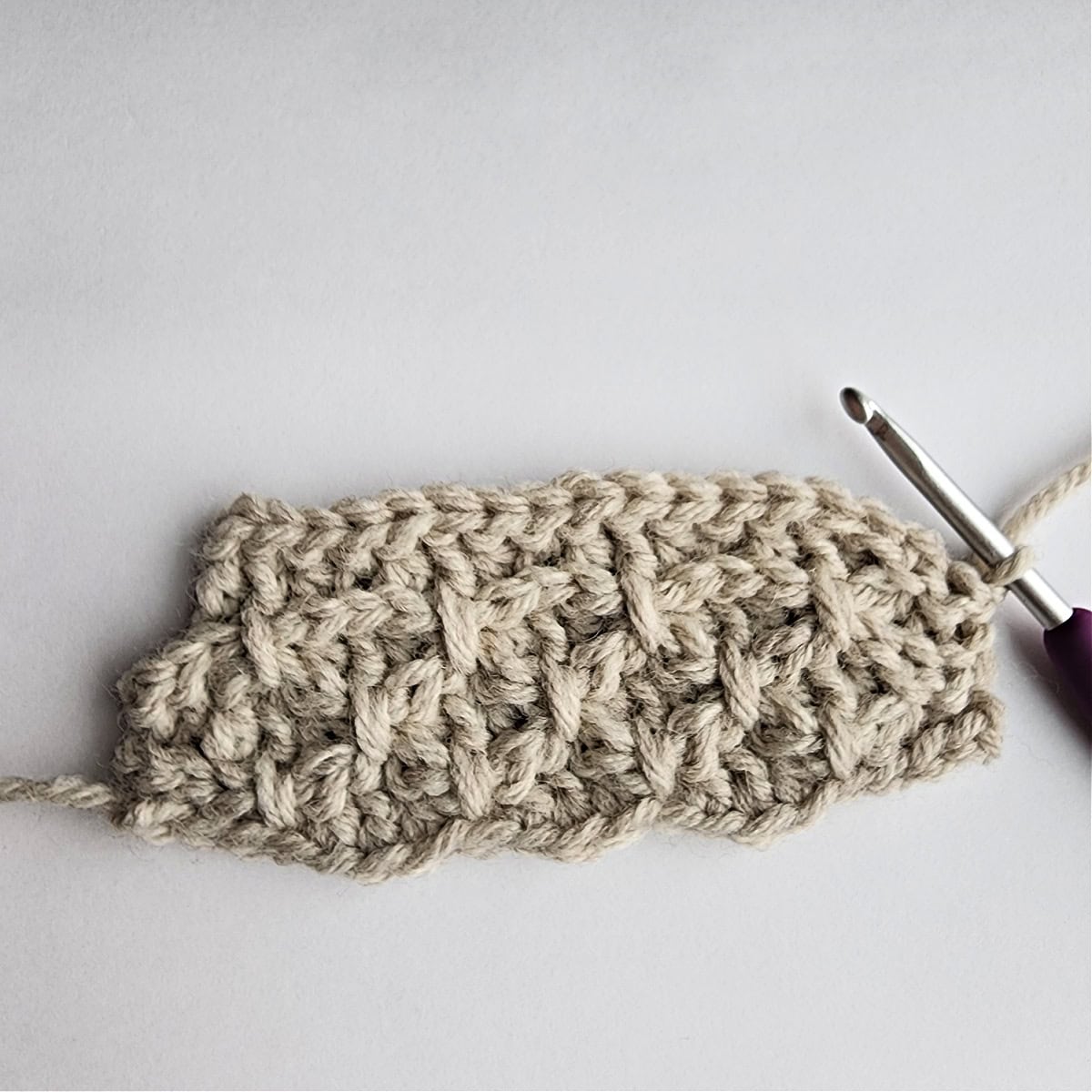 Starting row 9 of the crochet ornament with a purple crochet hook.