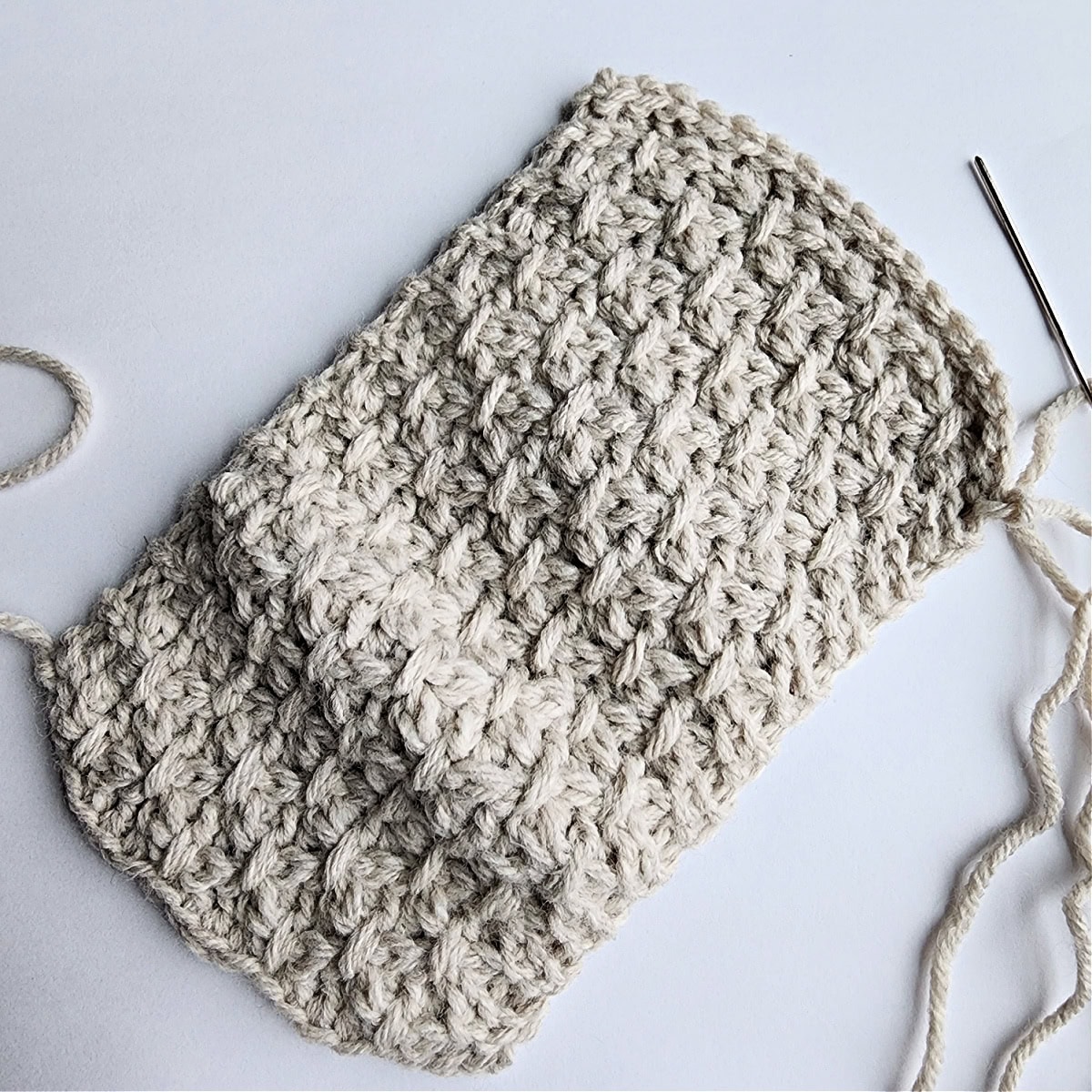 A flat piece of textured off-white crochet work for a bauble.