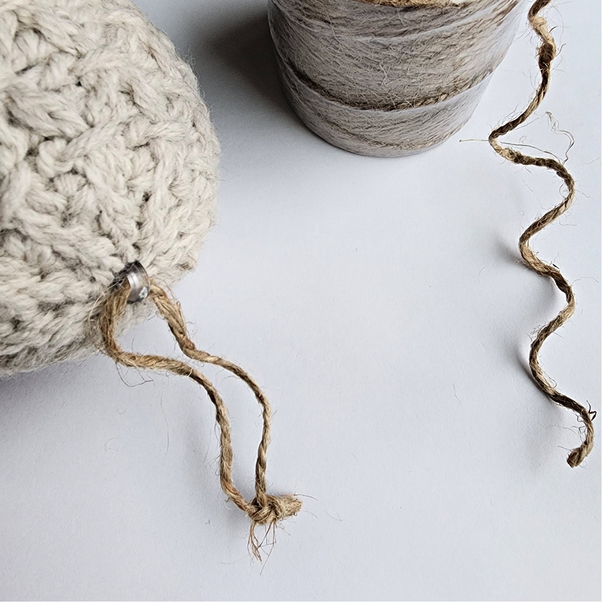 A spool of string next to a crochet ornament.