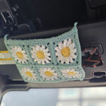 A crochet sunglasses car visor in a car made from six daisy granny squares.