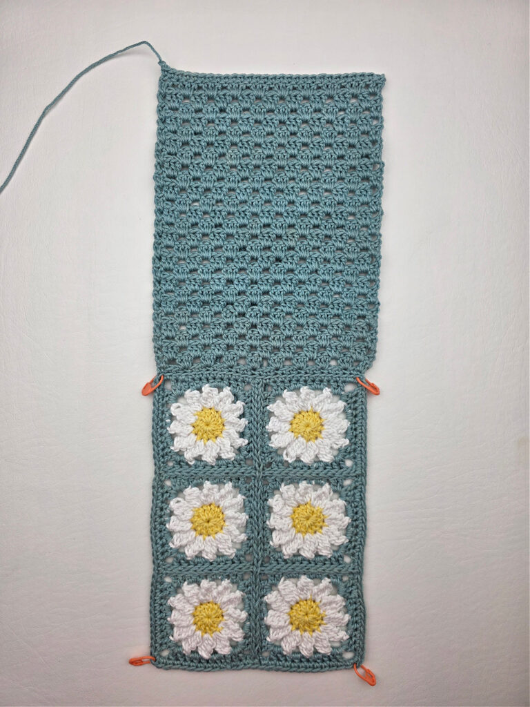 Six crochet daisy granny squares seamed together and a crochet panel.