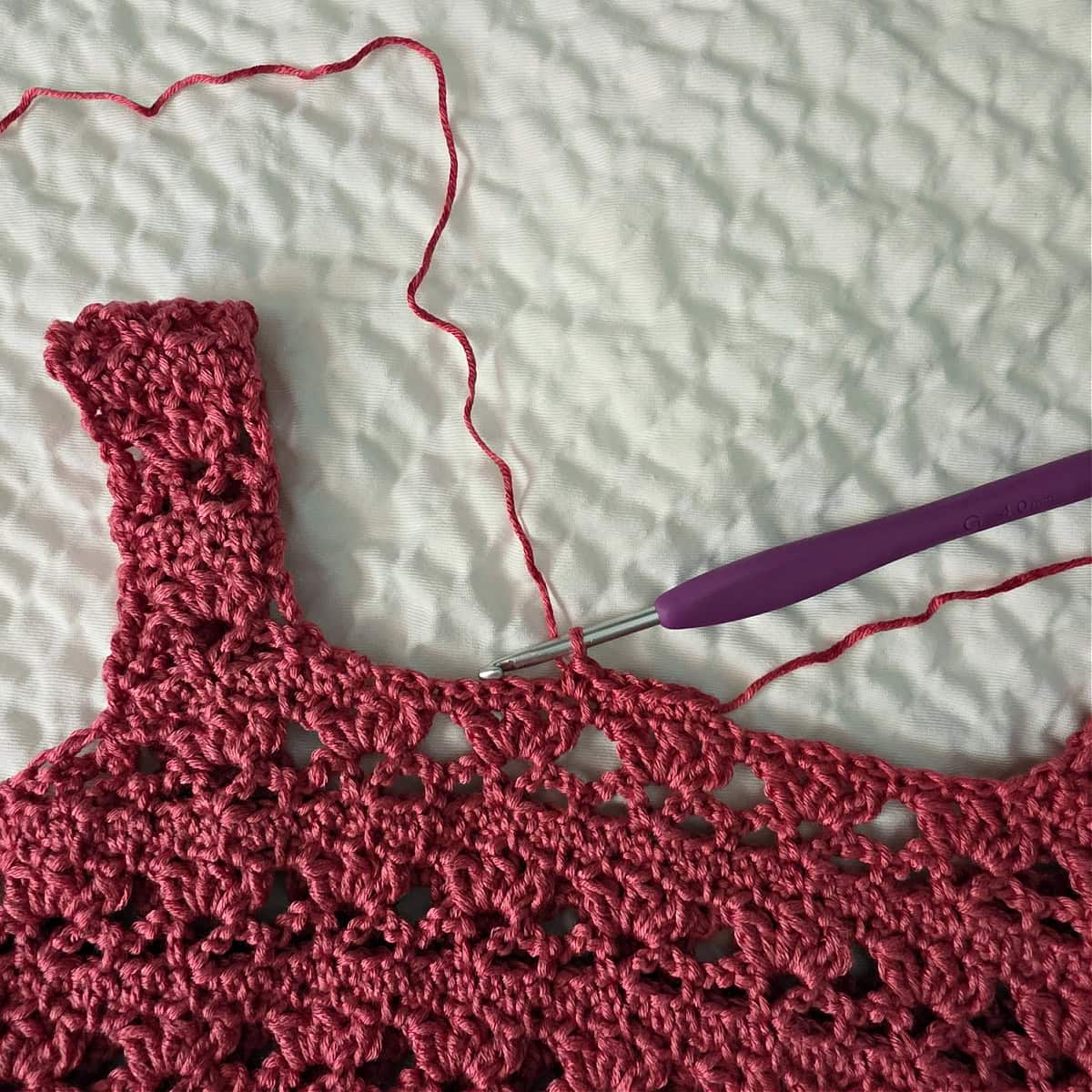 Neck opening of crochet tank top being edged.