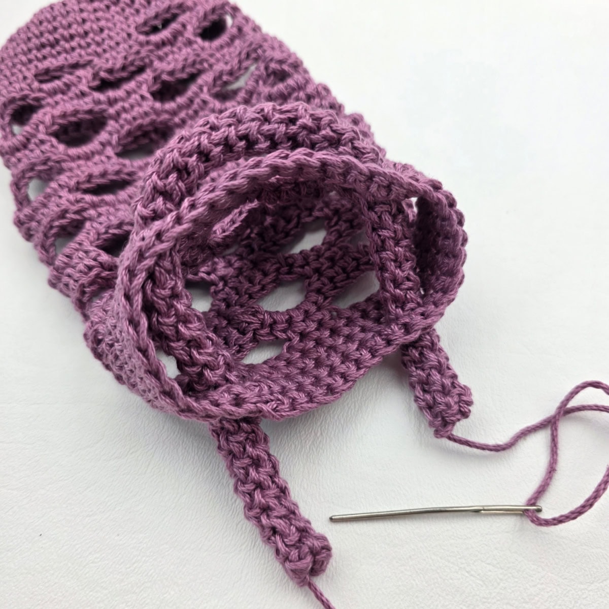 Attaching a crochet rope carabiner strap to a water bottle holder.