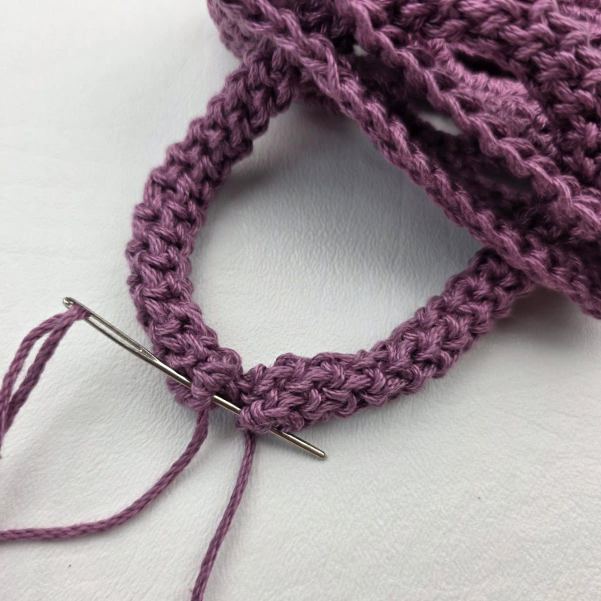 Attaching a crochet rope carabiner strap to a water bottle holder.