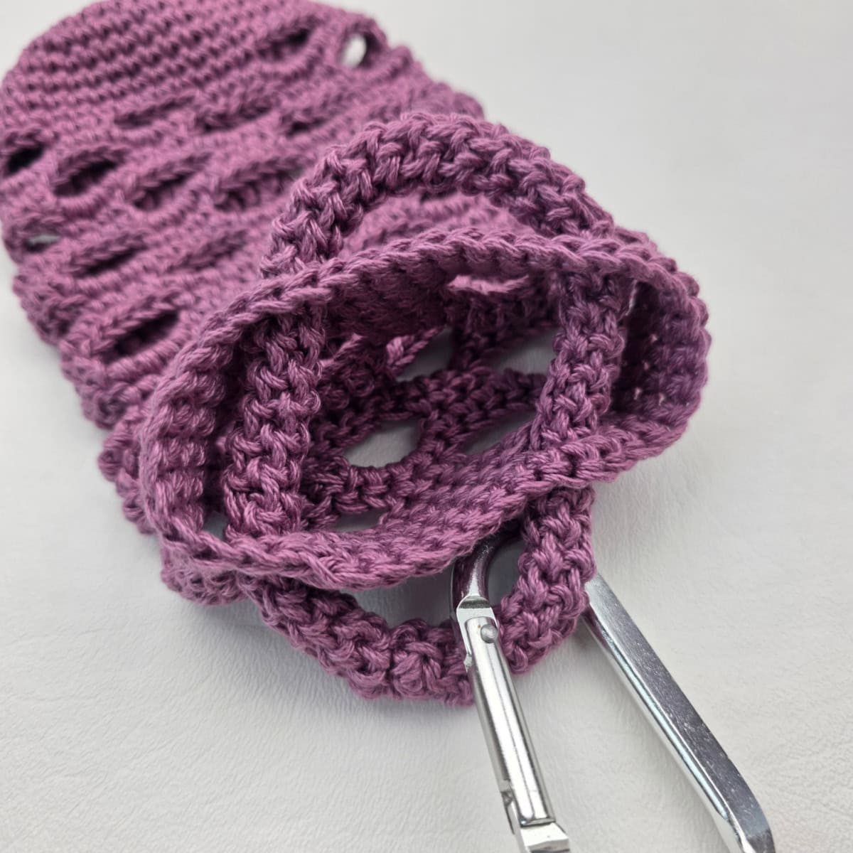 Attaching a crochet rope carabiner strap to a water bottle holder.