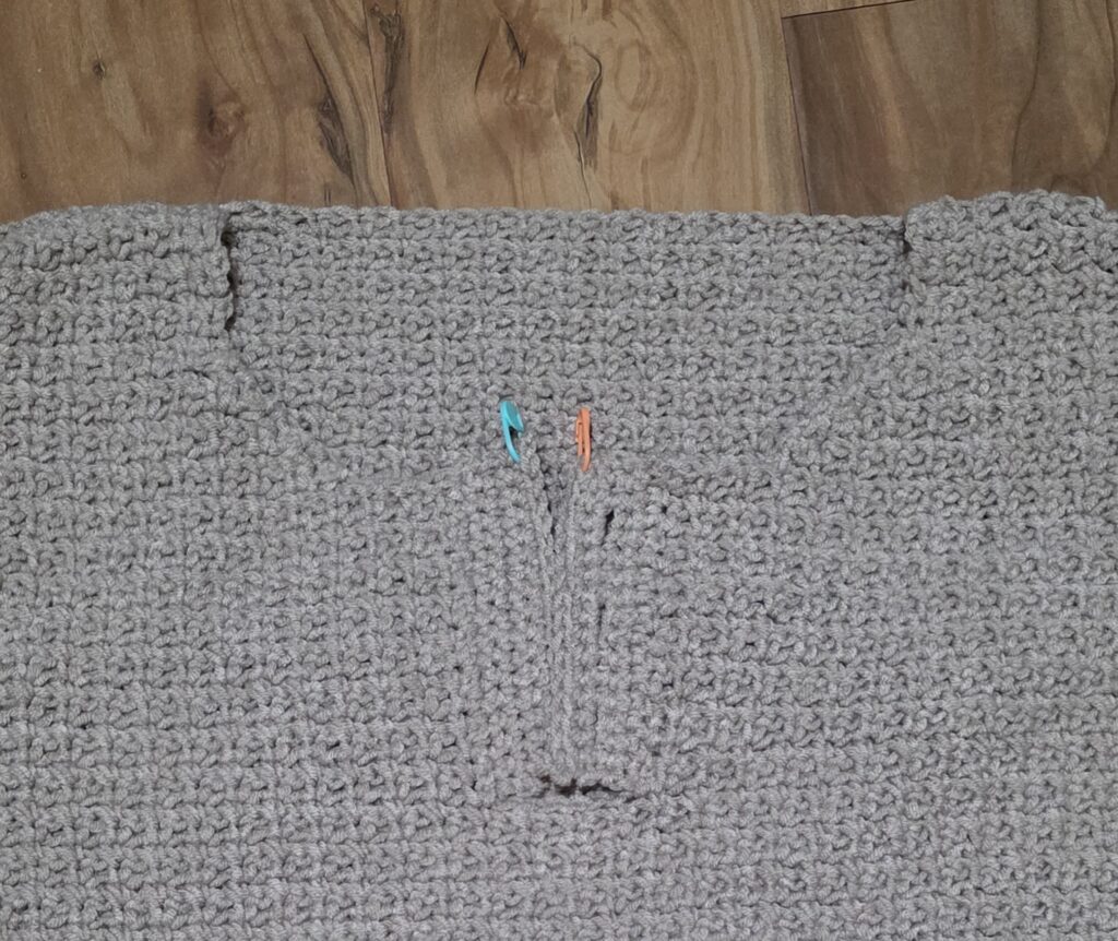 Working the edging around the neck opening of the crochet sweater.