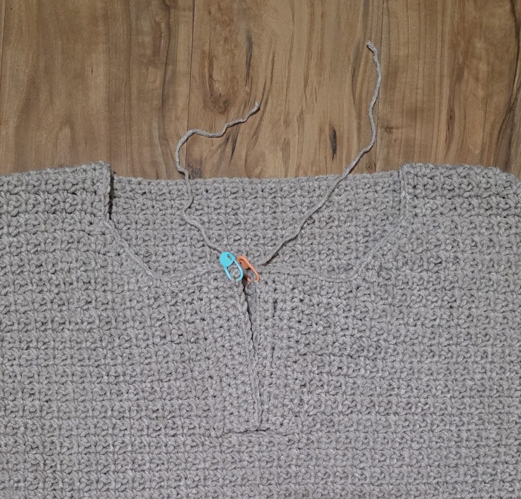Working the edging around the neck opening of the crochet sweater.