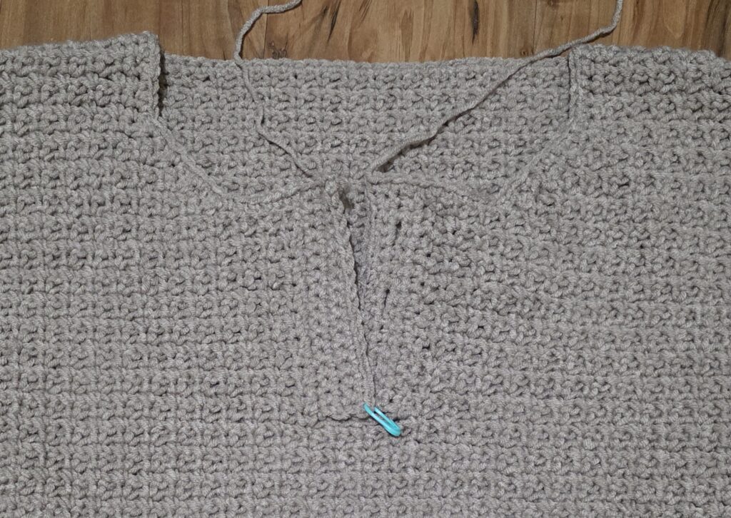 Working the edging around the neck opening of the crochet sweater.