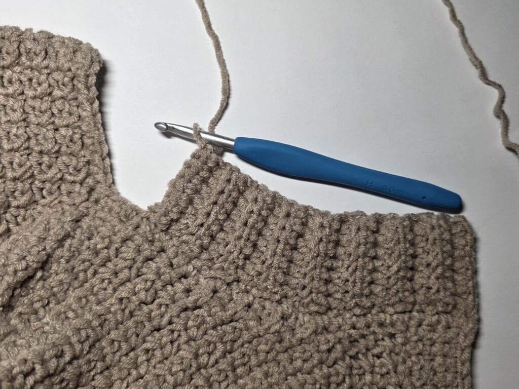 Working the collar ribbing of the crochet sweater.