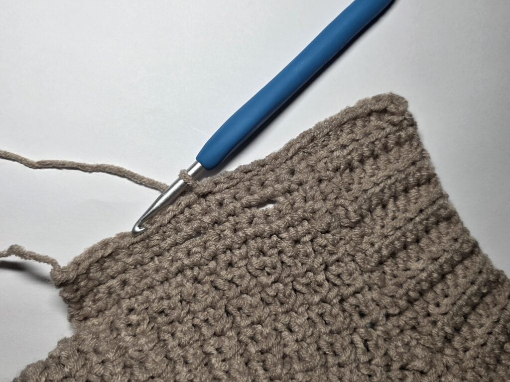 Working the collar ribbing of the crochet sweater.