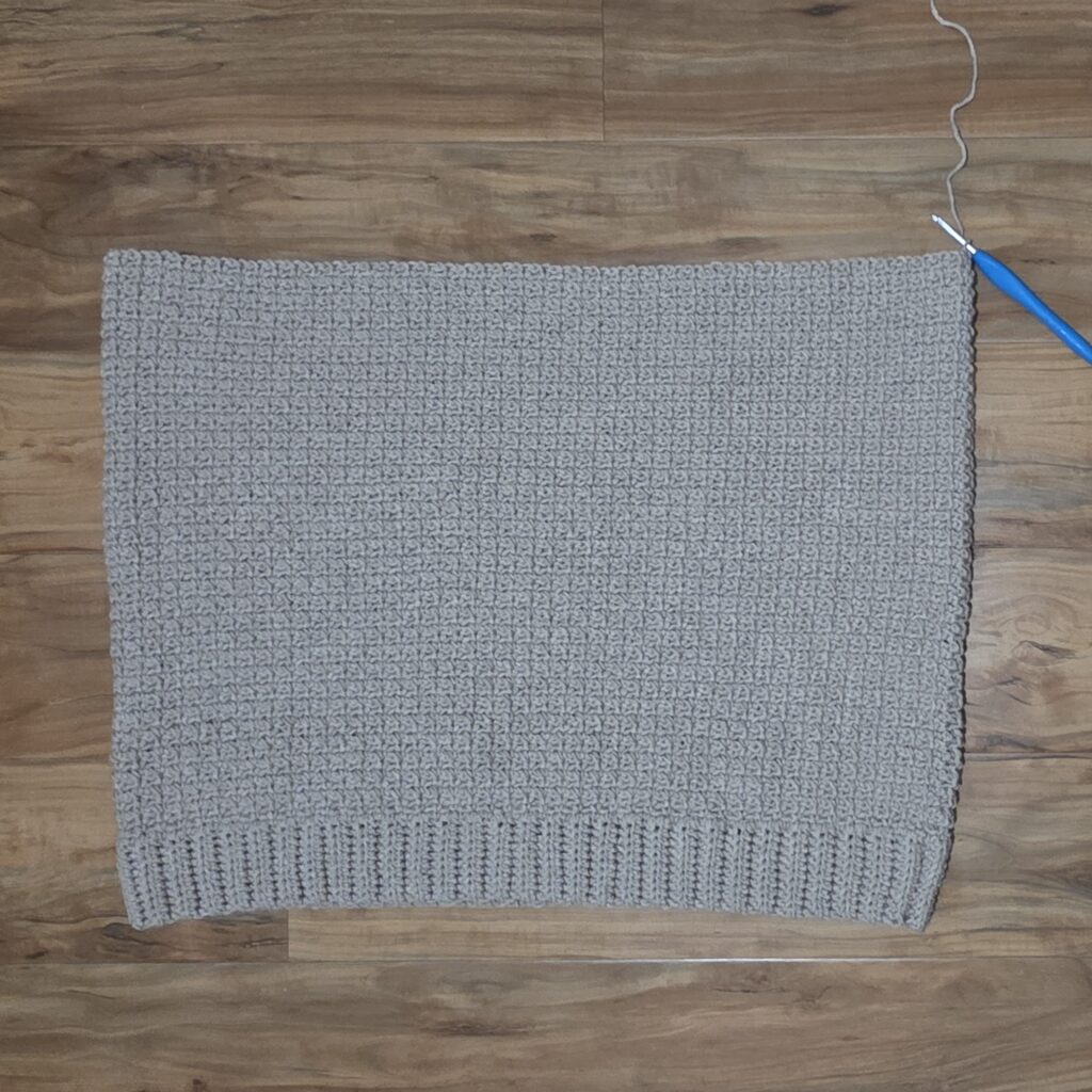 Completed body of a crochet sweater for men.
