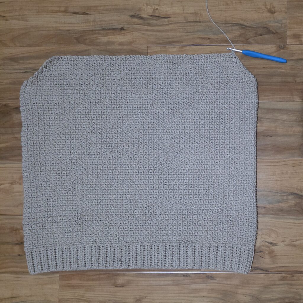 Working the upper front panel of the crochet sweater.