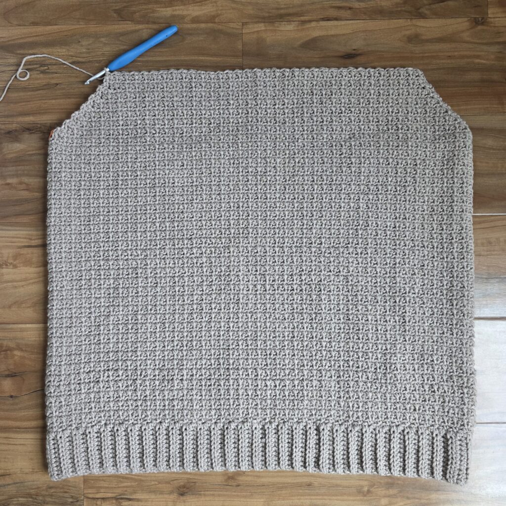 Working the upper front panel of the crochet men's sweater.