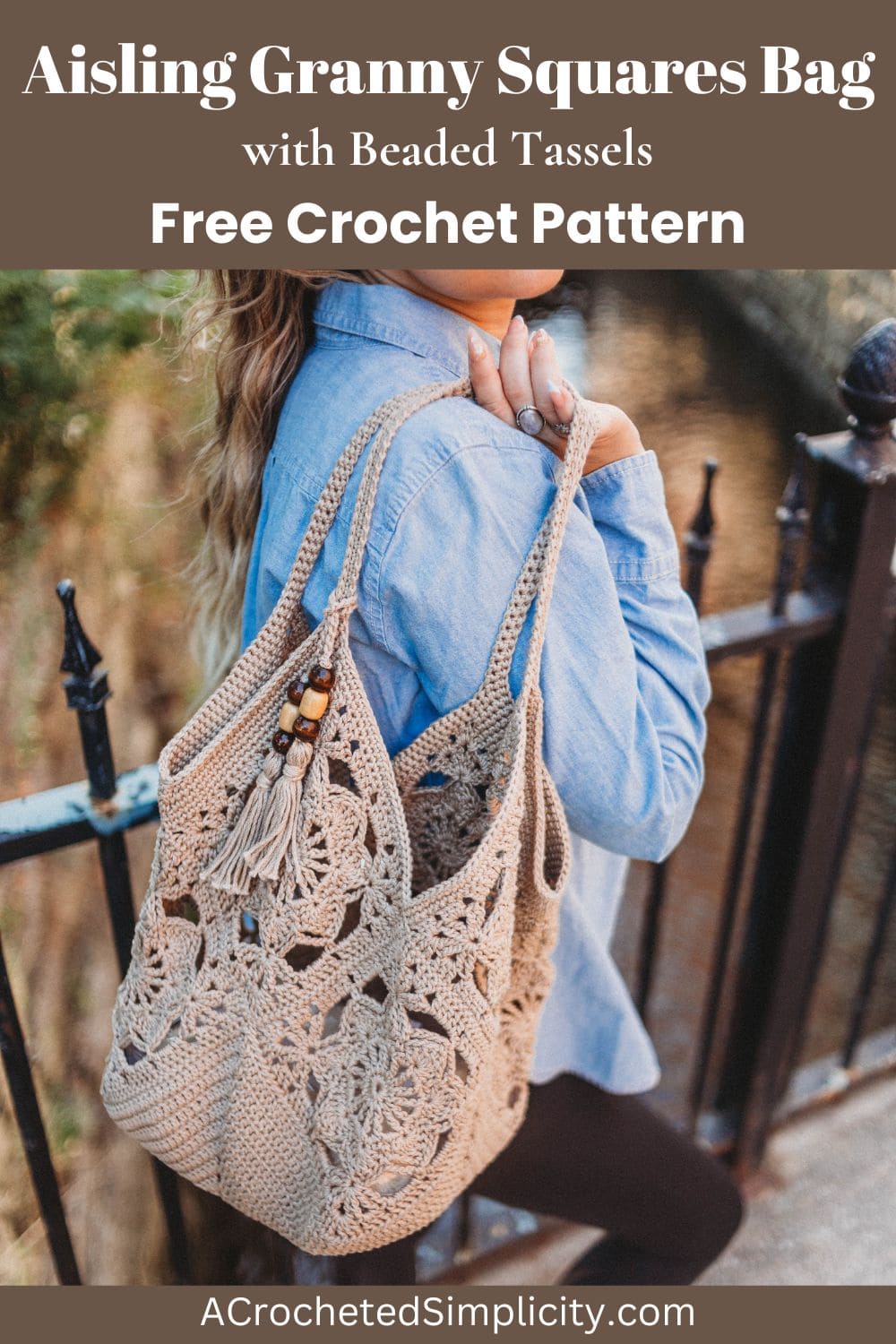 A girl wearing a blue shirt holding a crochet tote bag over her shoulder next to a fence.