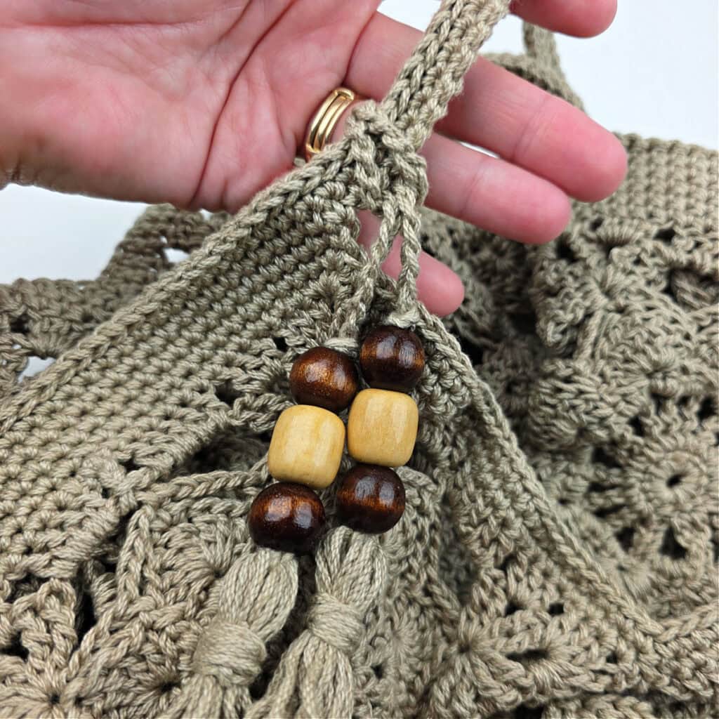 Tassels attached to the top of a crochet granny square bag.