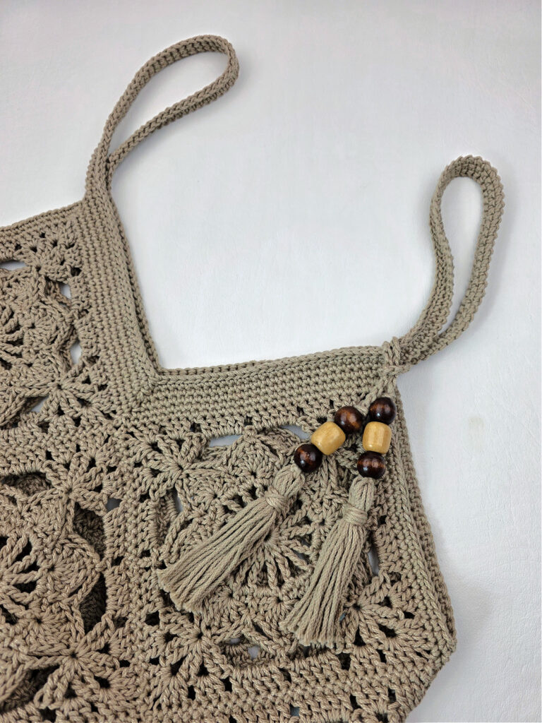 Tassels attached to the top of a crochet granny square bag.