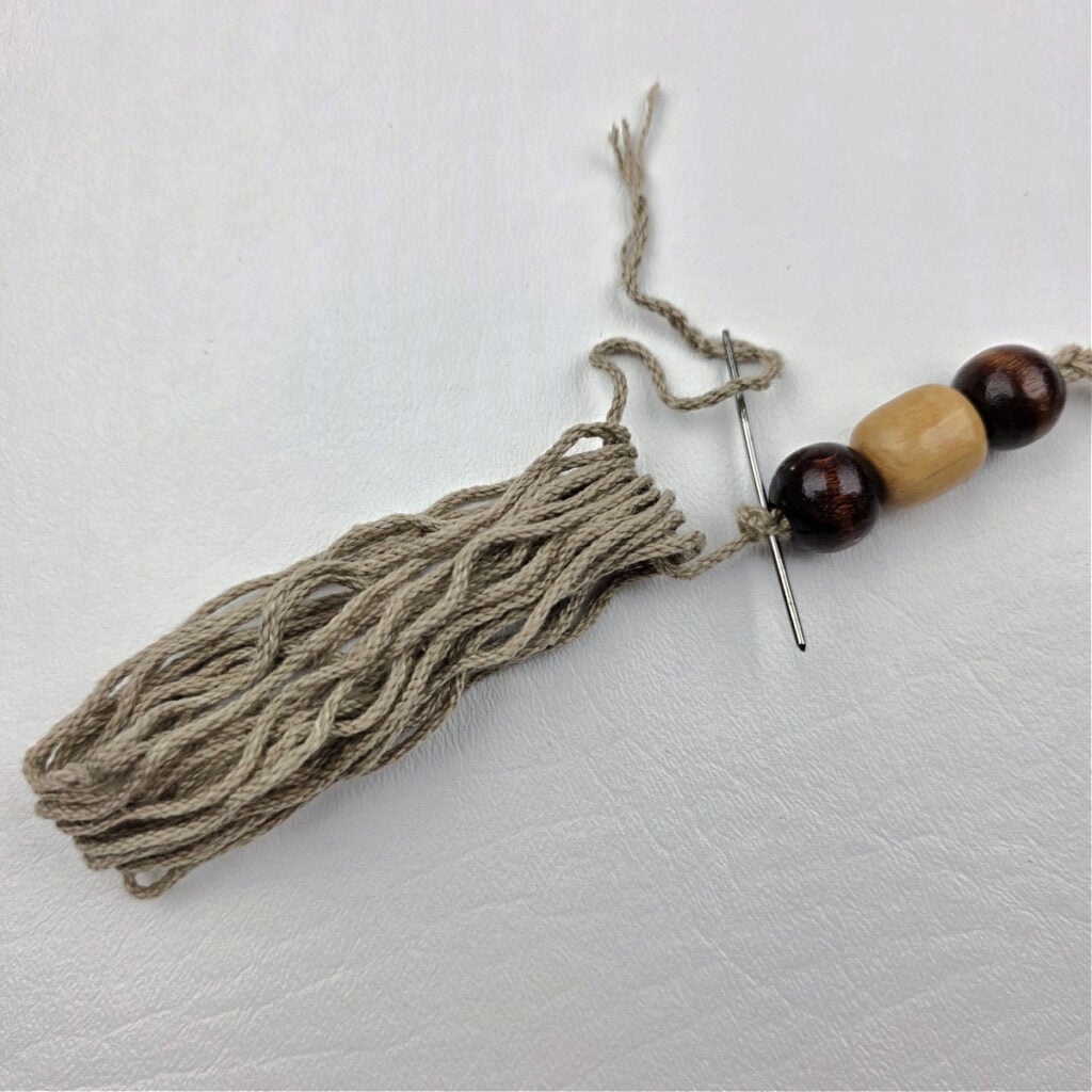 A handmade yarn tassel with beads.