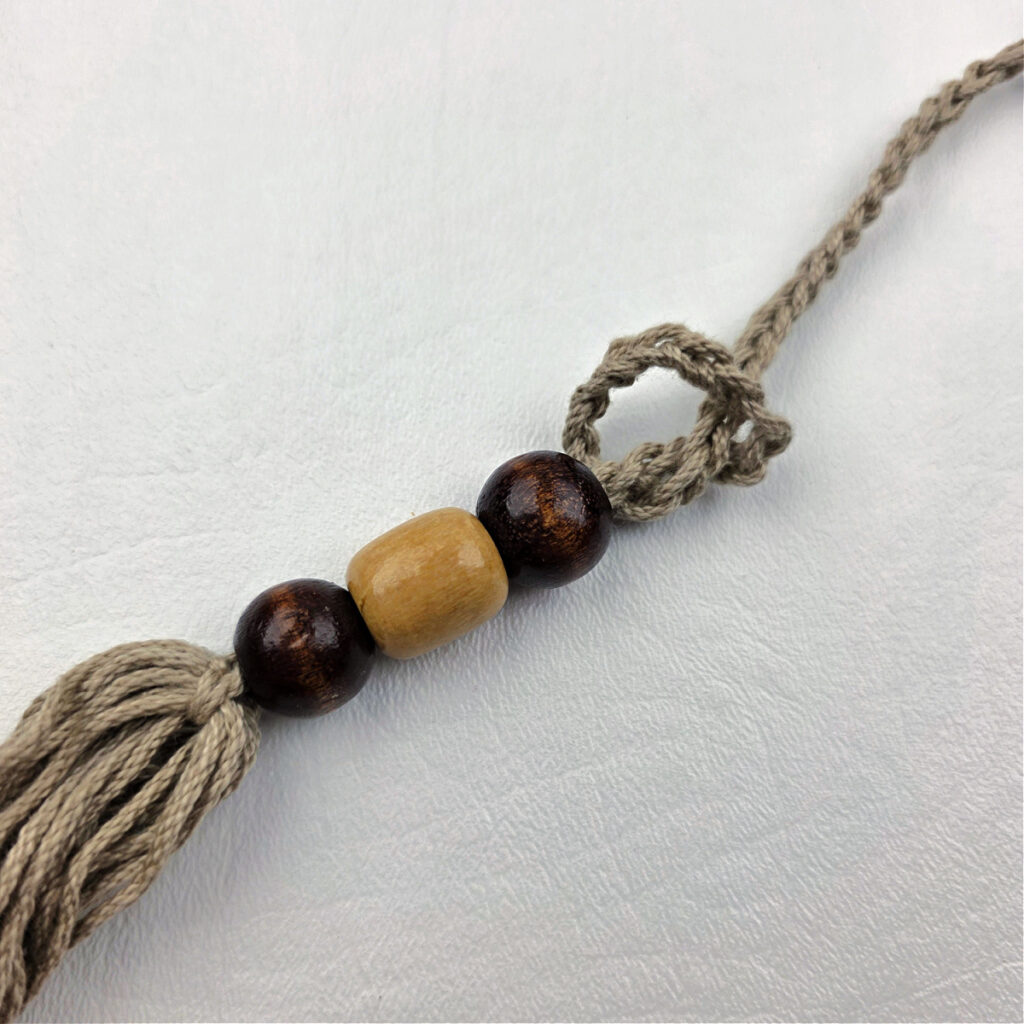 A handmade yarn tassel with beads.