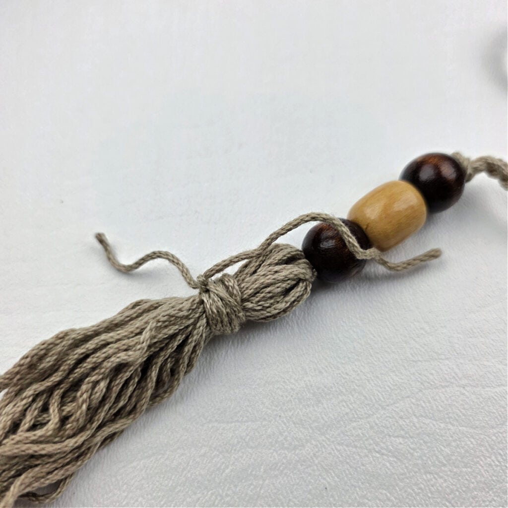 A handmade yarn tassel with beads.