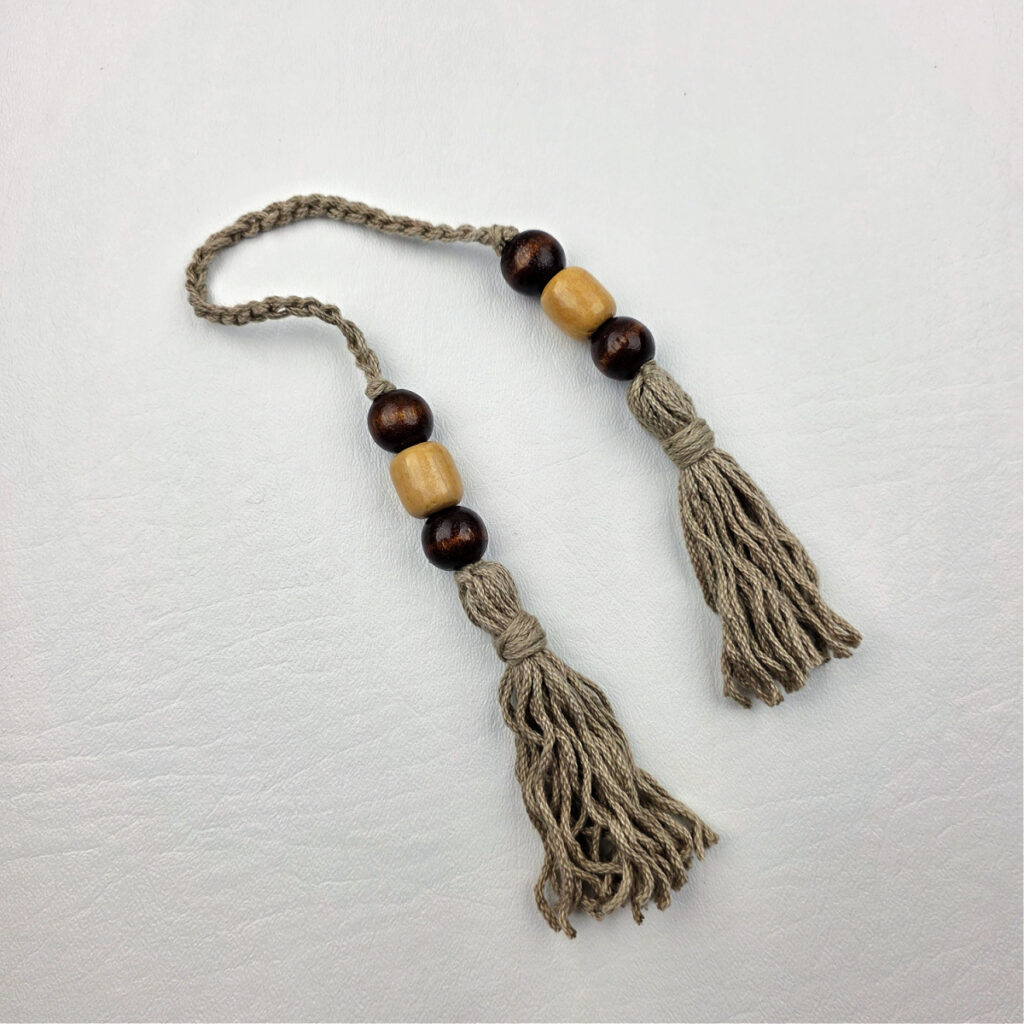 Two handmade yarn tassels with beads.