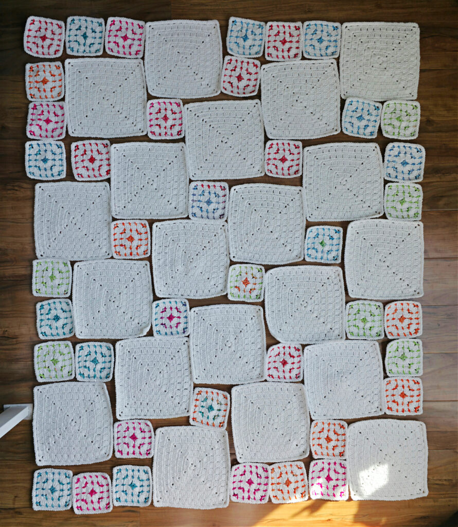Different sizes of crochet block stitch granny squares laid out in a blanket format.