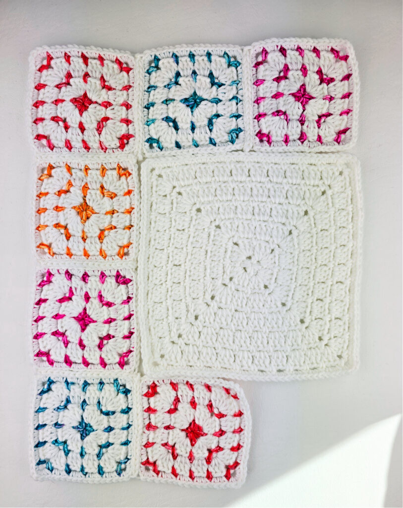 Different sizes of crochet block stitch granny squares laid out.