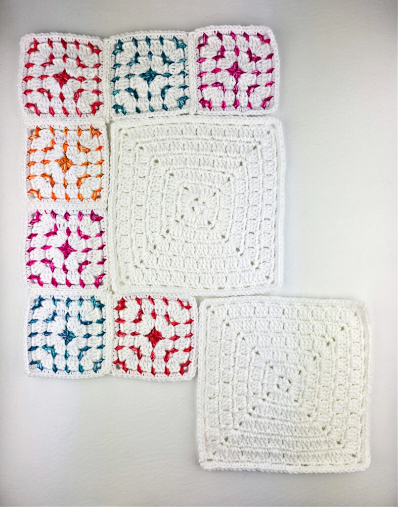 Different sizes of crochet block stitch granny squares laid out.