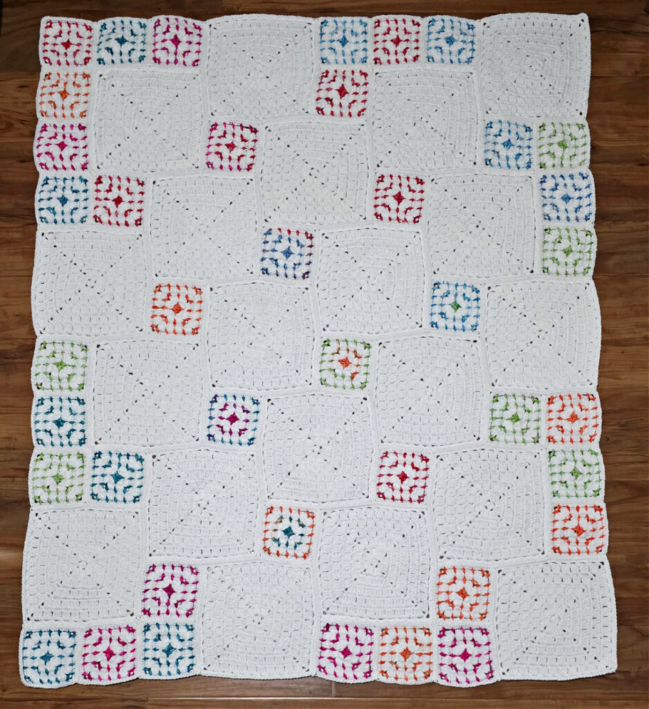 Different sizes of crochet block stitch granny squares laid out in a blanket format.