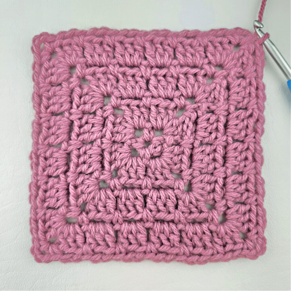 Making a block stitch granny square with a crochet hook.