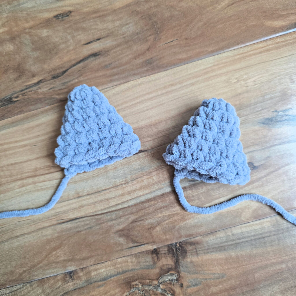 Crochet cat ears against a wooden floor.