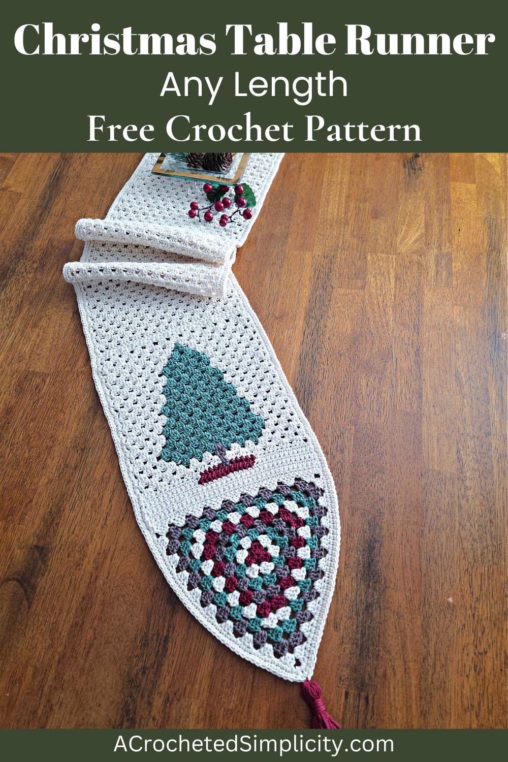 Crochet table runner on a wooden table with a fir tree and granny triangle at one end.