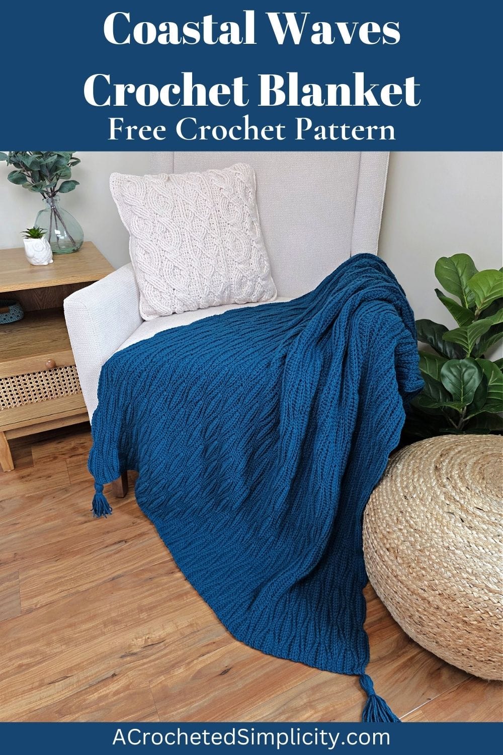 A dark blue crochet blanket draped over a sofa chair and wooden floor with a cushion next to it.